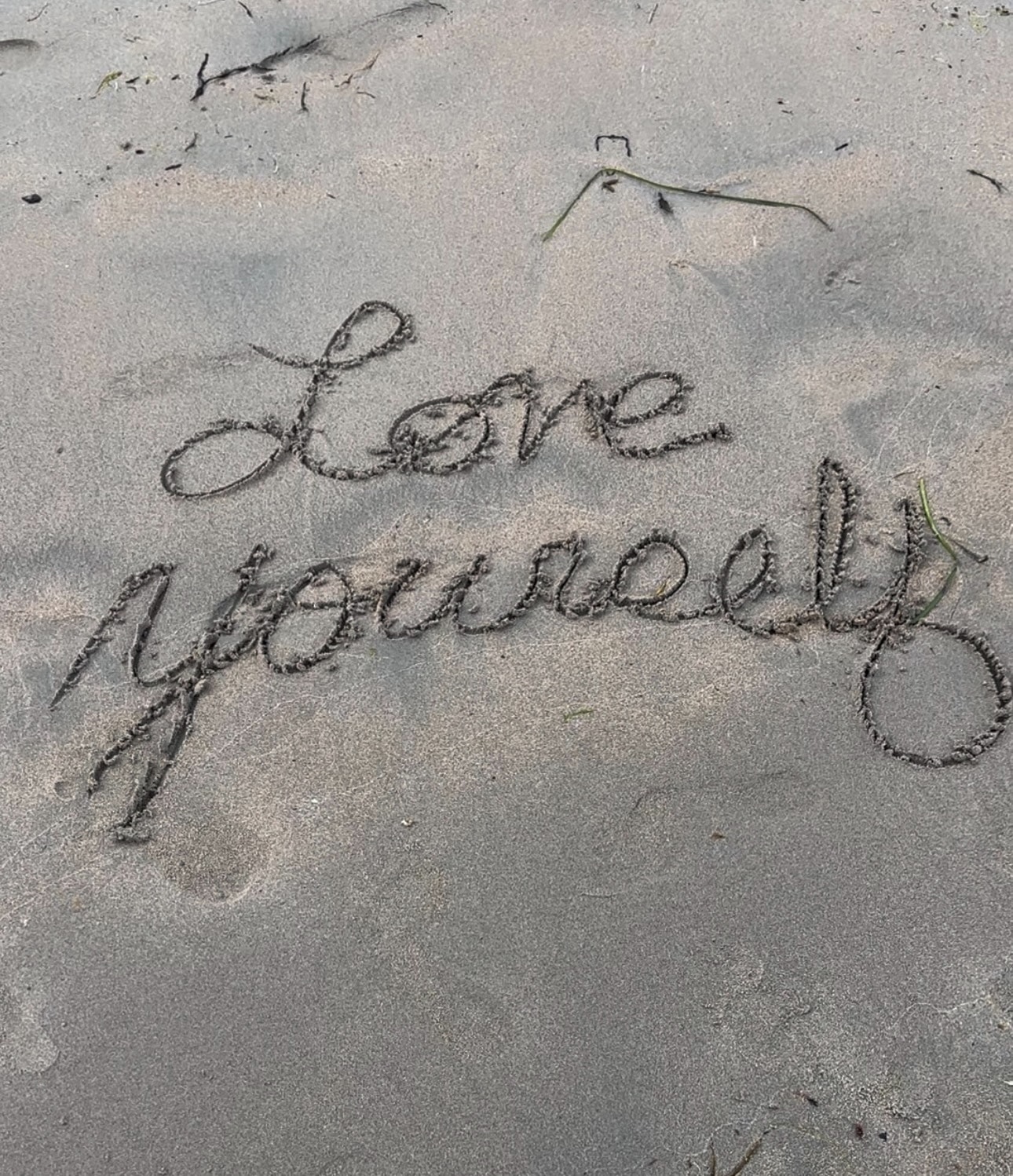 Love written in the sand at the beach