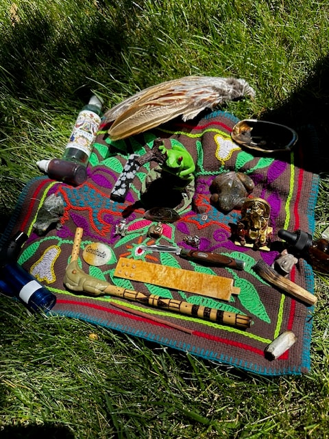 Kambo altar laid out on grass outdoors with ceremonial tools