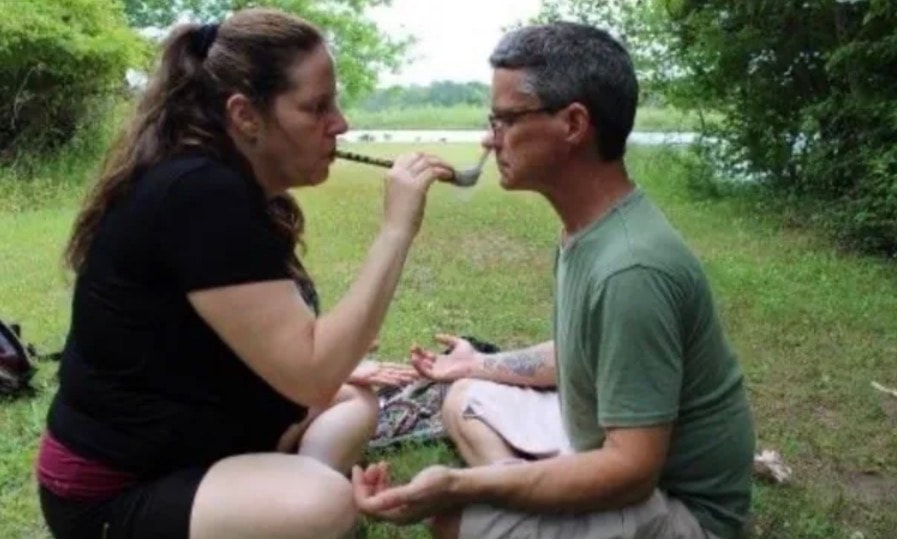 Angela administering Rapé medicine during a ceremony outdoors