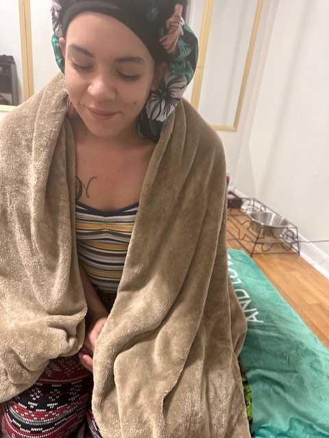 Natalie receiving Kambo medicine, wrapped in a blanket in a peaceful space
