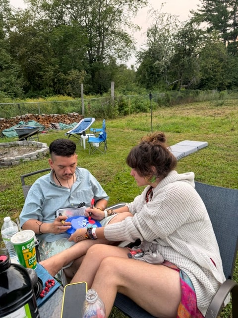 Two people sitting outdoors in a garden during a healing session