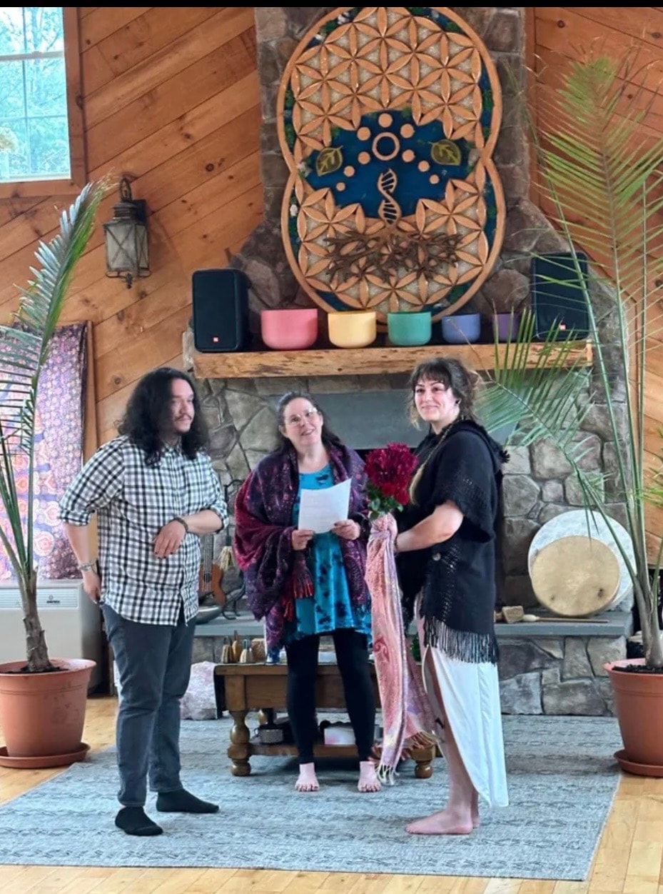 Angela officiating a ceremony in a beautiful sacred space with a Flower of Life mandala