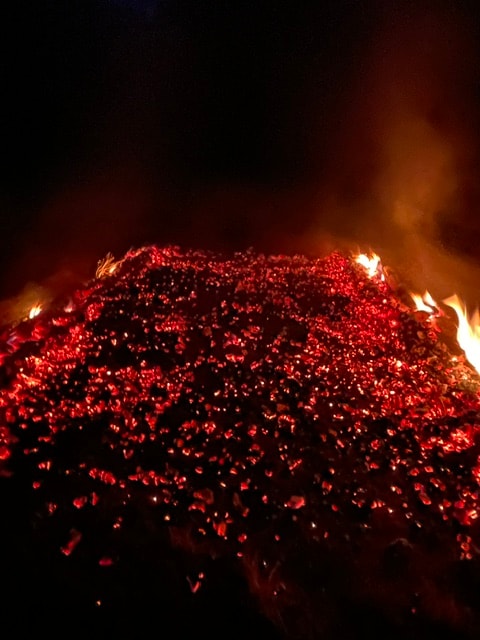Glowing red hot coals at night during a firewalk ceremony
