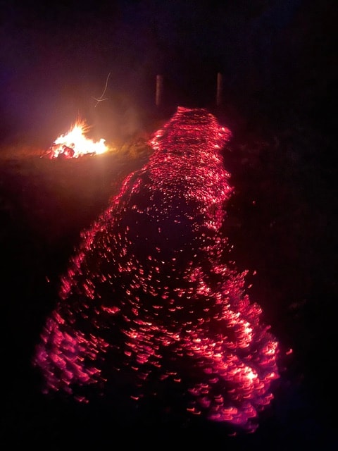 Glowing red ember path at night during a firewalk ceremony